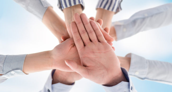 Business people hands stacked in a pile. A symbol of teamwork and trust.